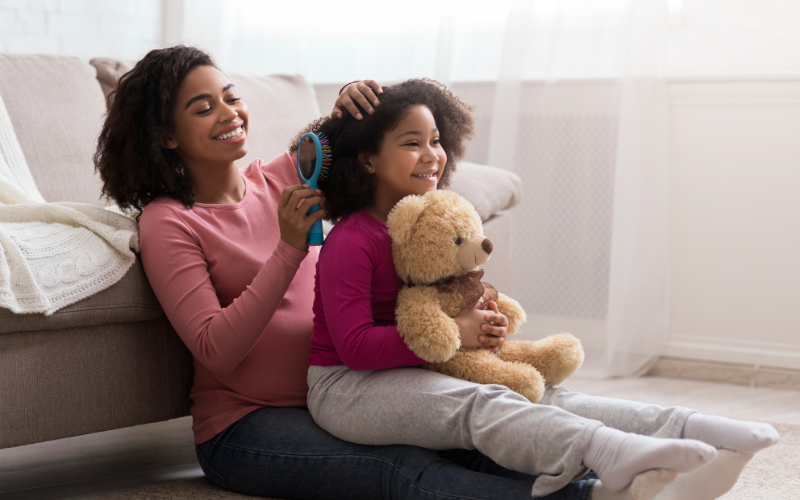 Mom detangling kids curly hair